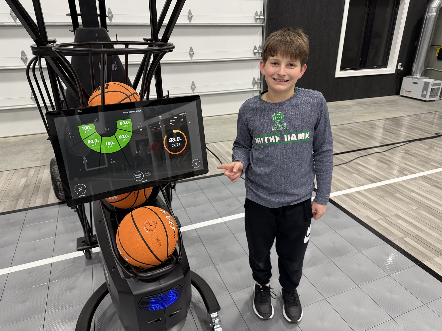 Young athlete reviewing results on the Dr. Dish automated basketball shooting machine